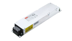 Rectangular metal power supply module with a black terminal block at one end and warning labels on the side.