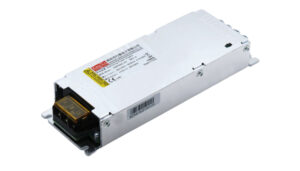 Metal enclosed power supply unit with a yellow terminal block at the end and label stickers on top, angled view.