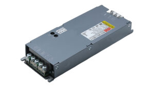 Industrial metal DC power supply module with screw terminals on one end and caution labels on top; used to provide regulated output voltage/current to equipment.